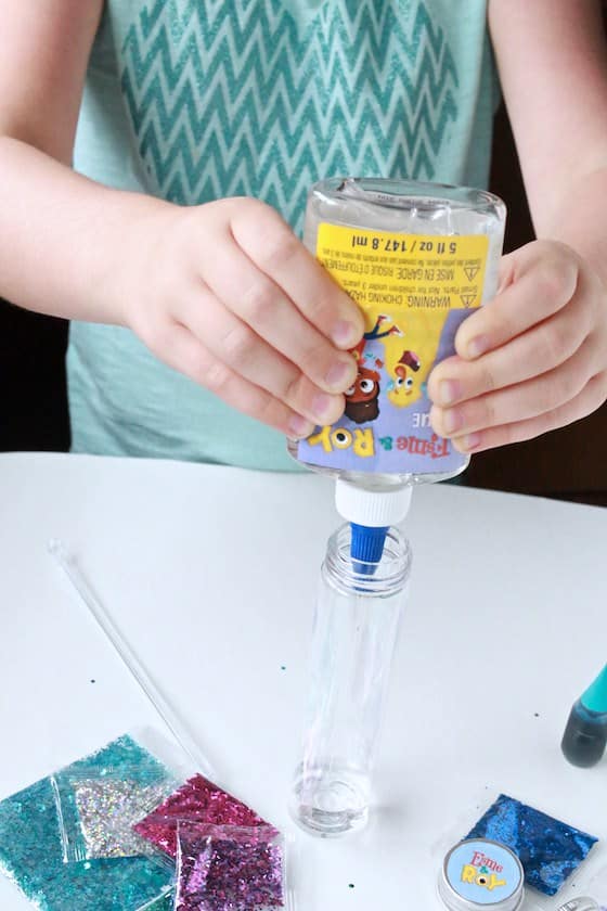 squeezing glue into glitter bottle