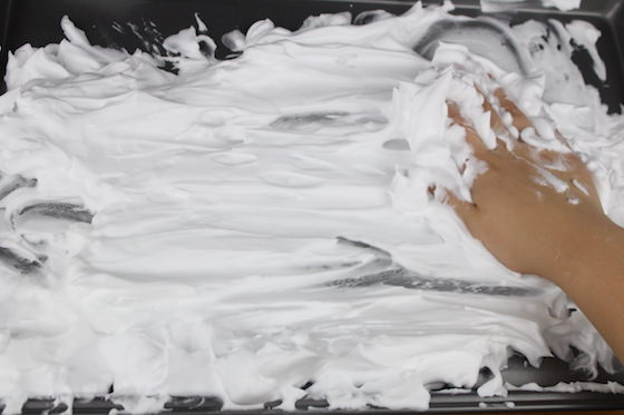 child's hand in shaving cream.