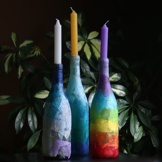 3 wine bottles with candles