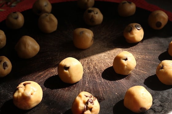 chocolate chip cookie dough rolled in balls on baking stone