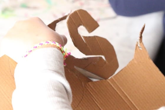 Child cutting letter S out of cardboard