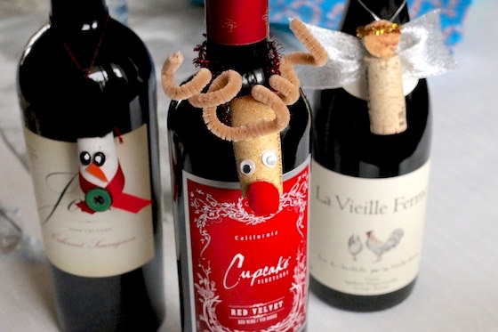 Cork snowman, reindeer and angel ornaments hanging on wine bottles
