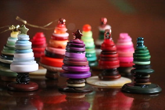 10 Small Christmas tree ornaments made with colourful buttons standing on tabletop