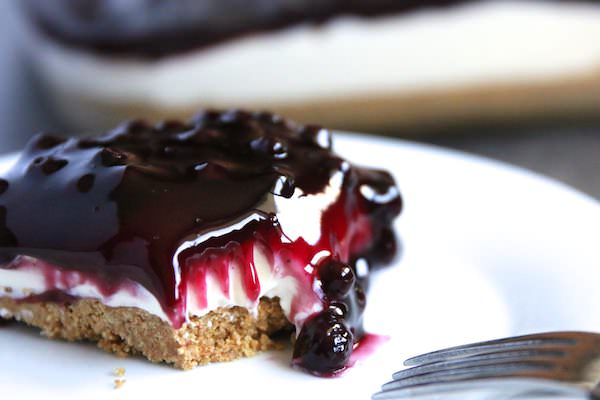 close up blueberry no-bake cheesecake on white plate with fork