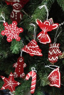 red and white painted cardboard christmas ornaments hanging on tree