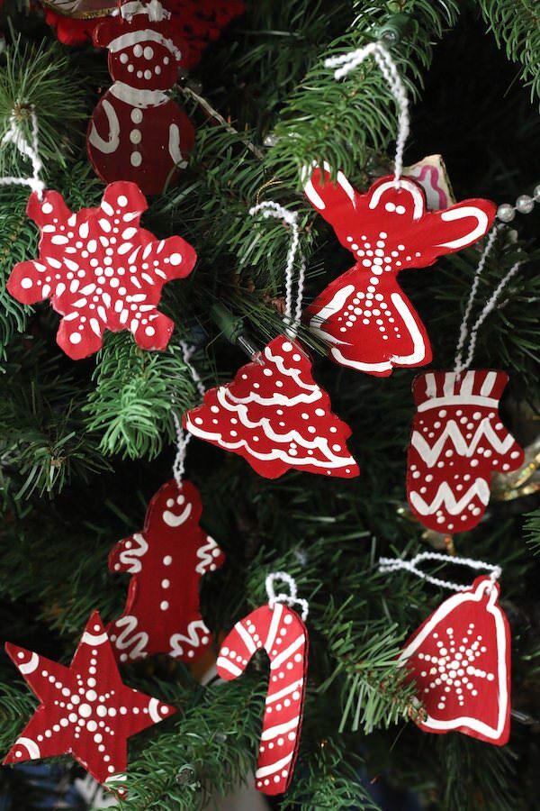 red and white painted cardboard christmas ornaments hanging on tree