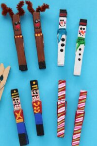 painted clothespin reindeer, snowmen, nutcrackers and candy canes on blue background