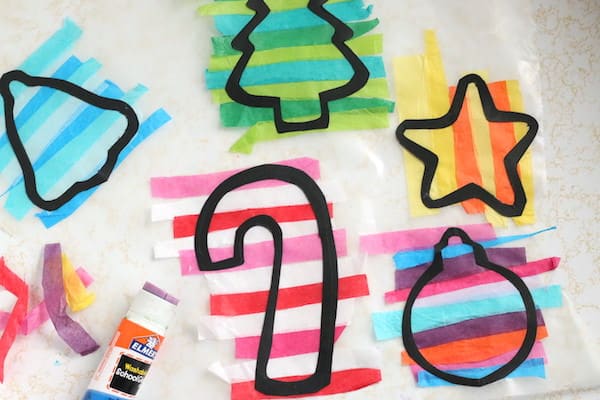 colourful tissue paper strips laid over black cookie cutter outlines