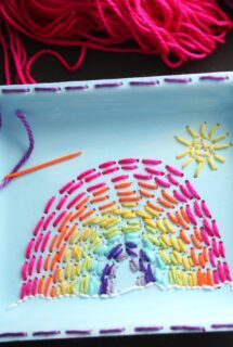 kid sewn rainbow on produce tray with small sun and orange sewing needle