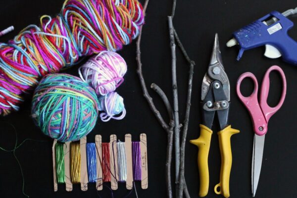 Variegated yarn, twigs, garden shears, scissors, metallic thread