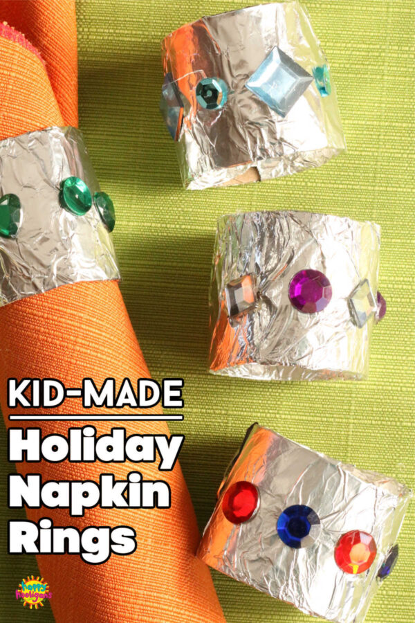 tinfoil covered cardboard roll napkin rings with gems and sequins, orange napkin on green table cloth