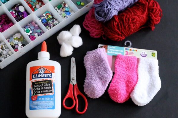 baby socks, glue, cotton balls, yarn, gems